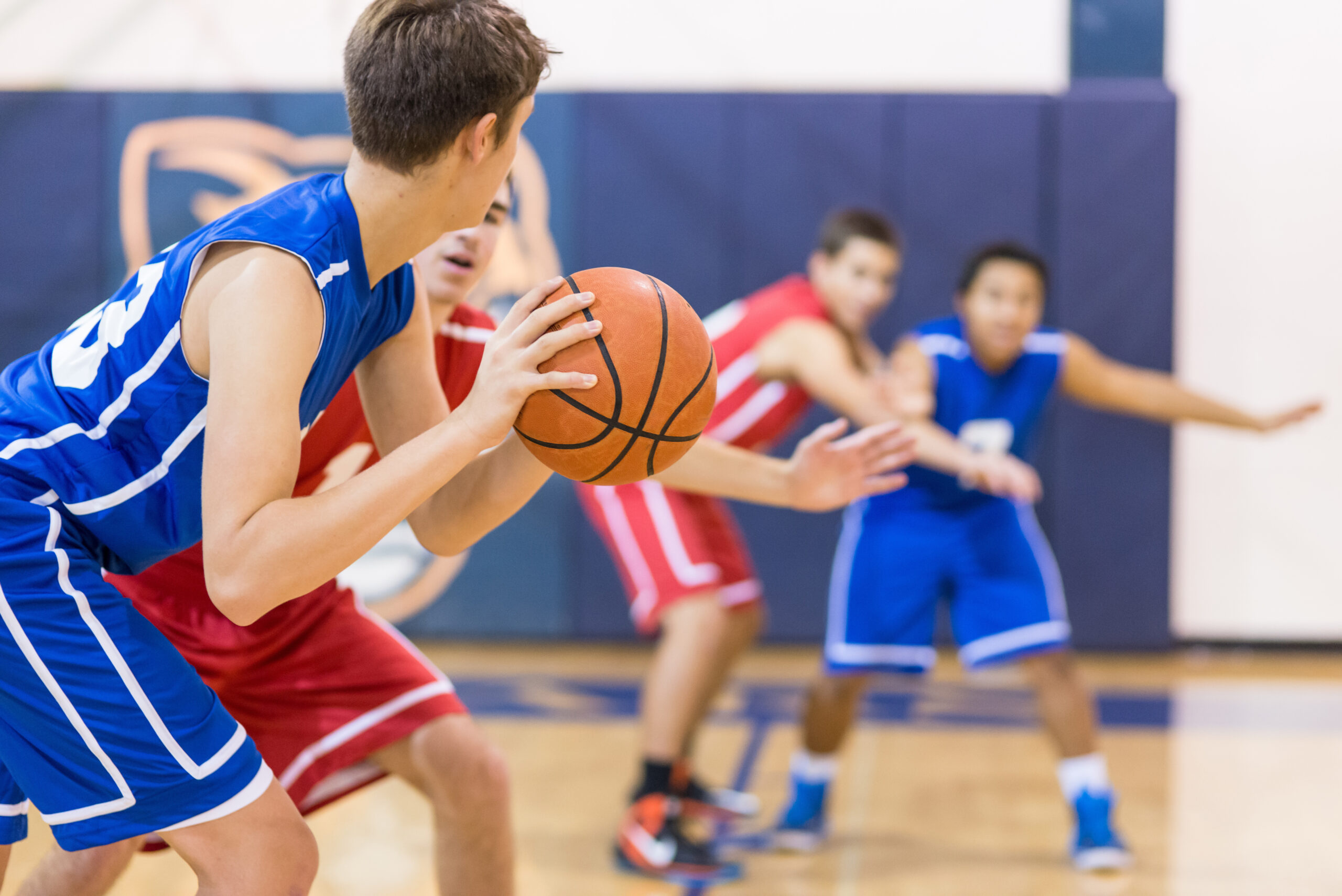 Boys high school basketball team: player about to shoot over defender