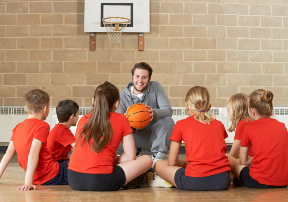 Coach Giving Team Talk To Elementary School Basketball Team